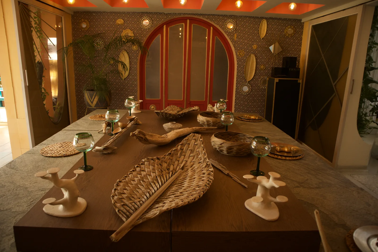 Comedor con techo artesonado naranja y mesa de piedra