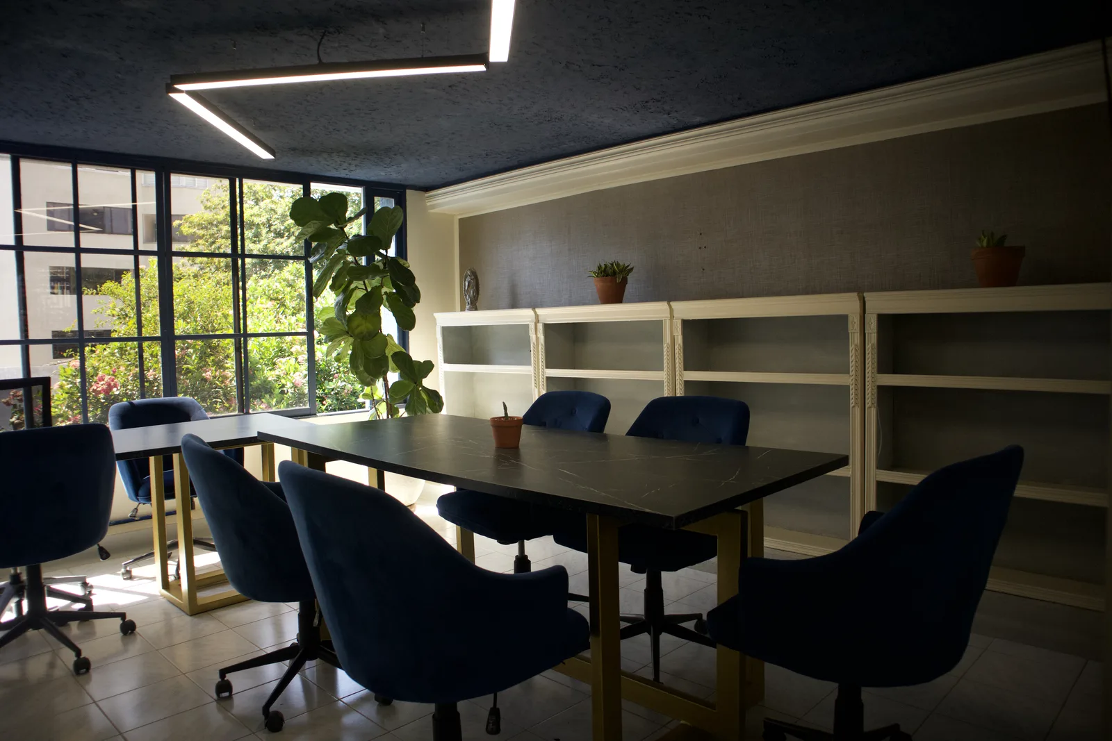 Sala de juntas con mesa de mármol negro y sillas de terciopelo azul