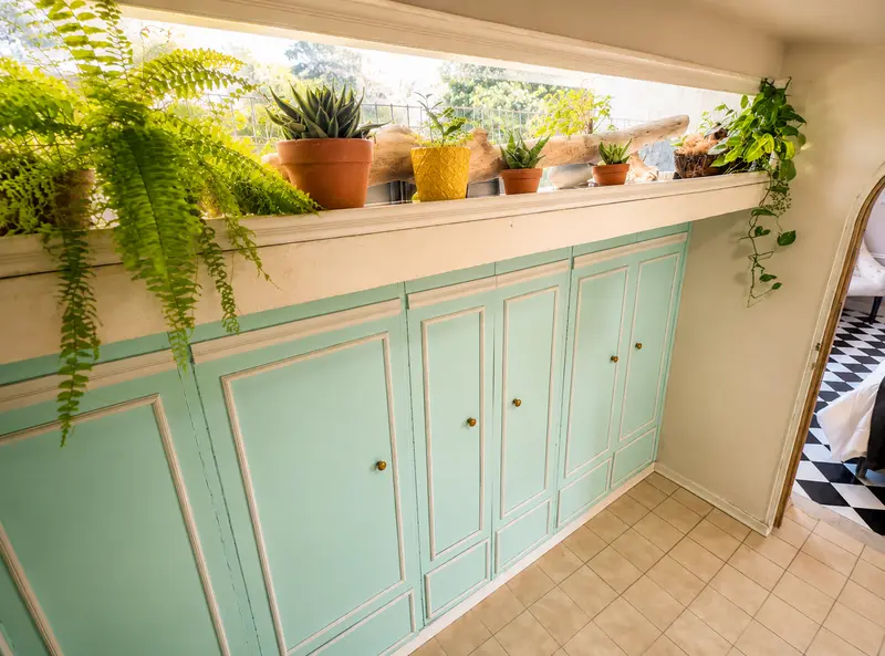 Baño verde menta con plantas colgantes