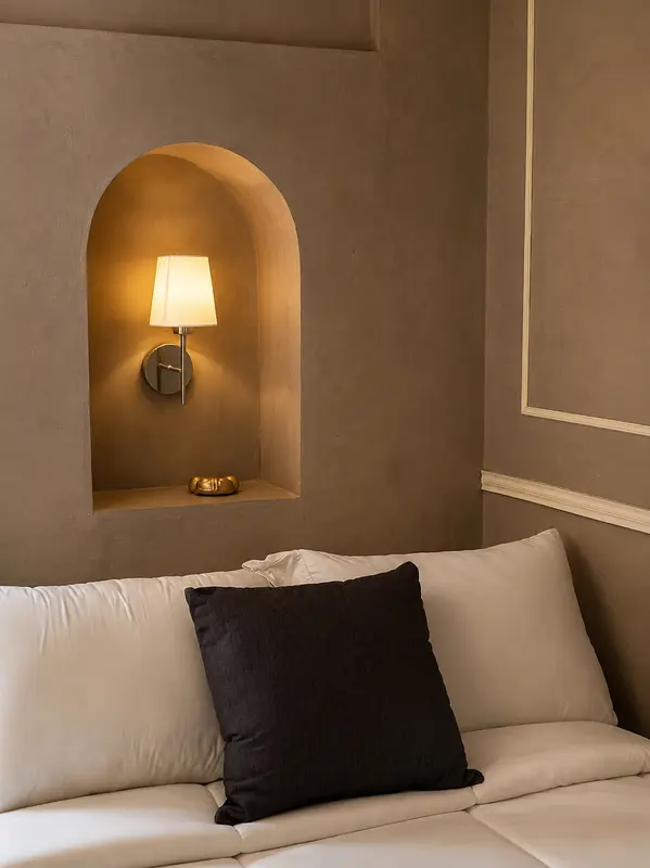 Lámpara en nicho de arco junto a la cama